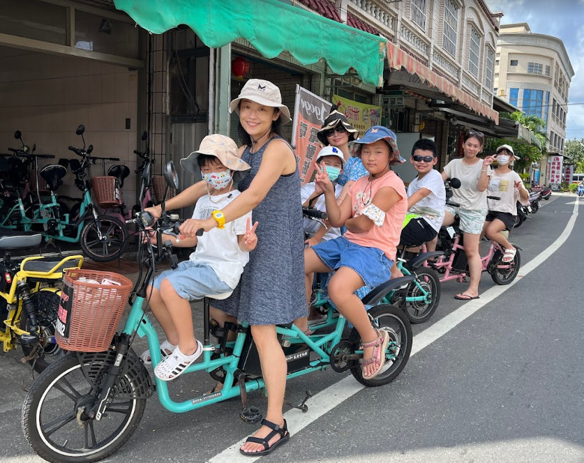 A group of people are riding tandem bicycles down a street.