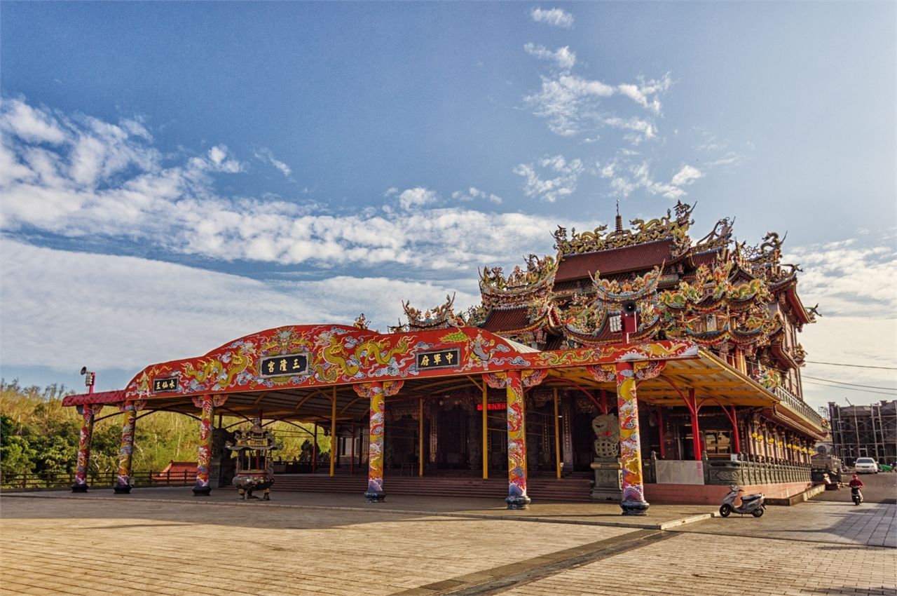 A large chinese temple with a blue sky in the background.
