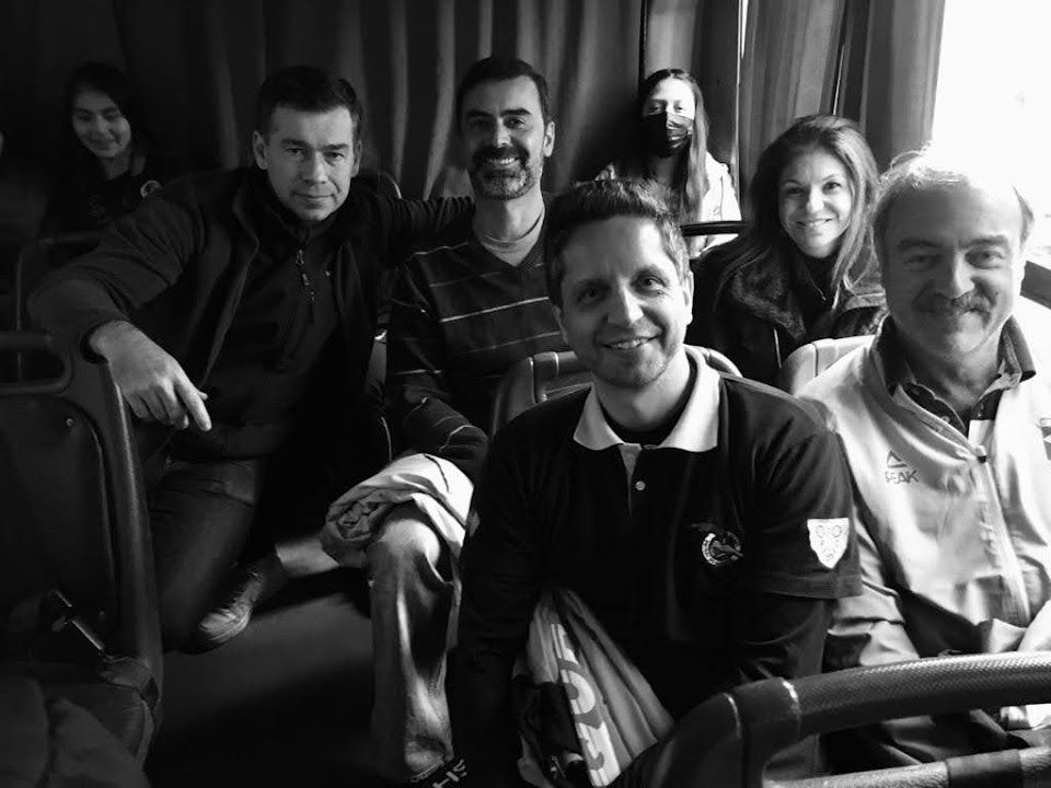 Uma foto em preto e branco de um grupo de pessoas sentadas em um ônibus.