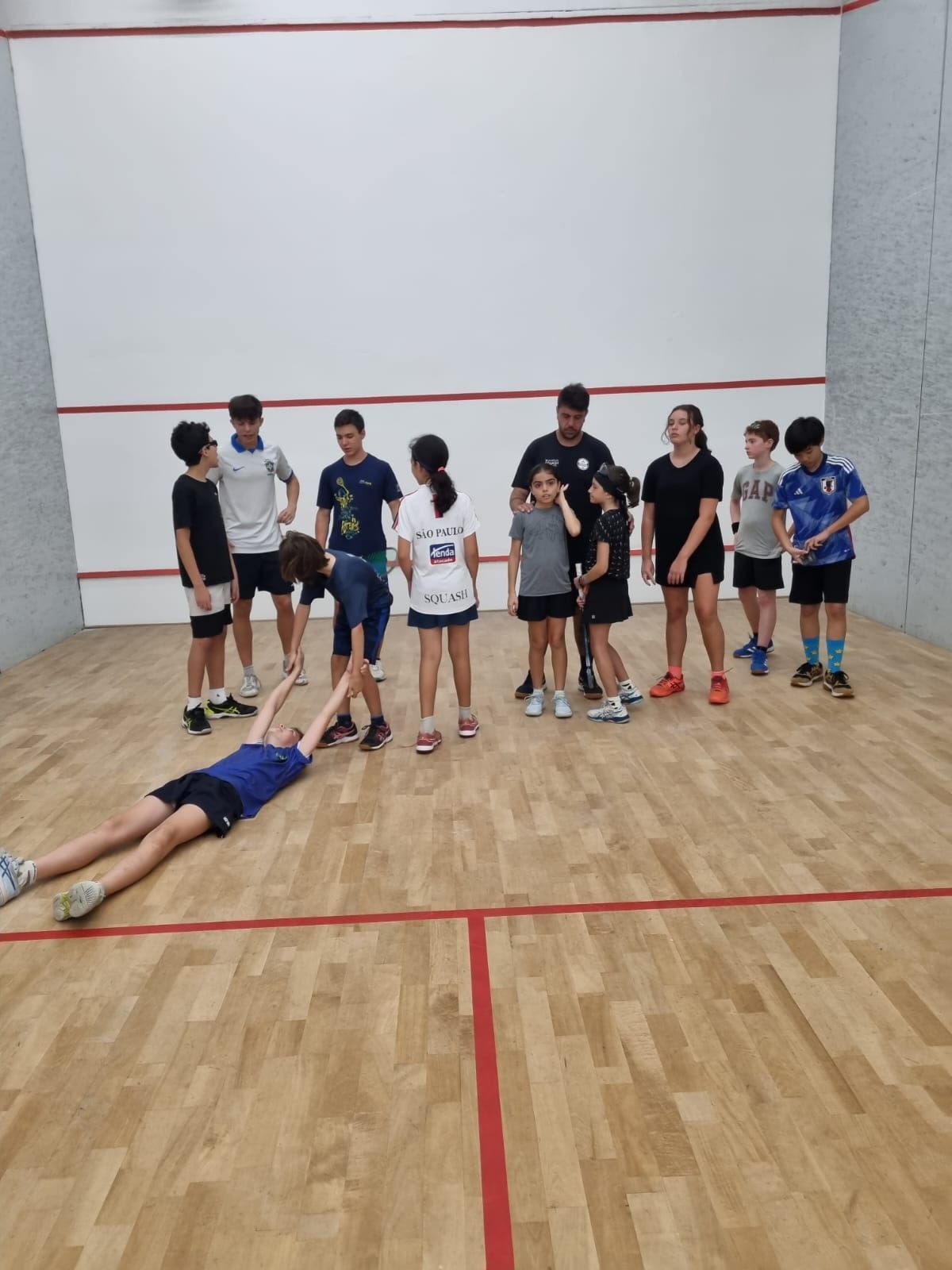 Um grupo de crianças está jogando squash em uma quadra