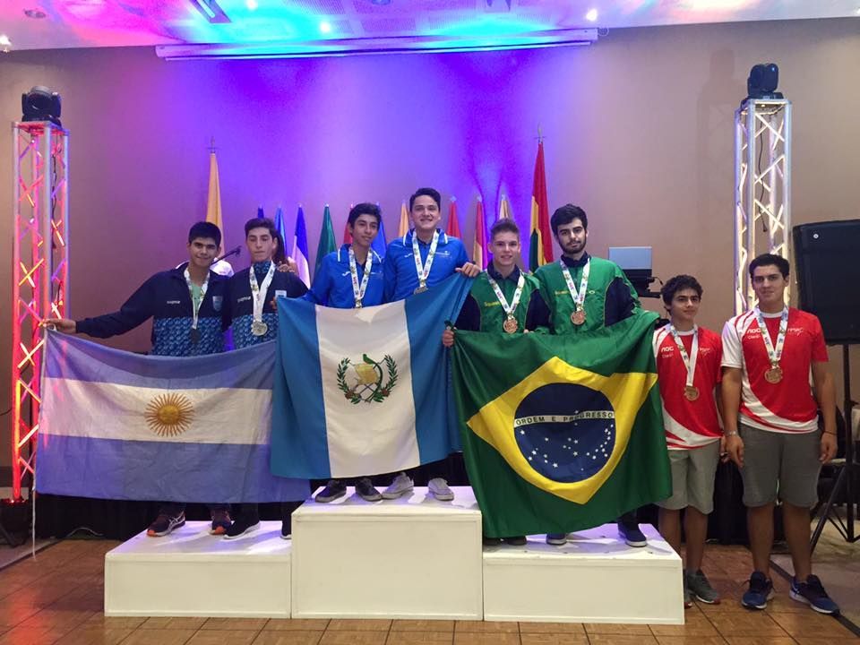 um grupo de jovens está em um pódio segurando bandeiras.