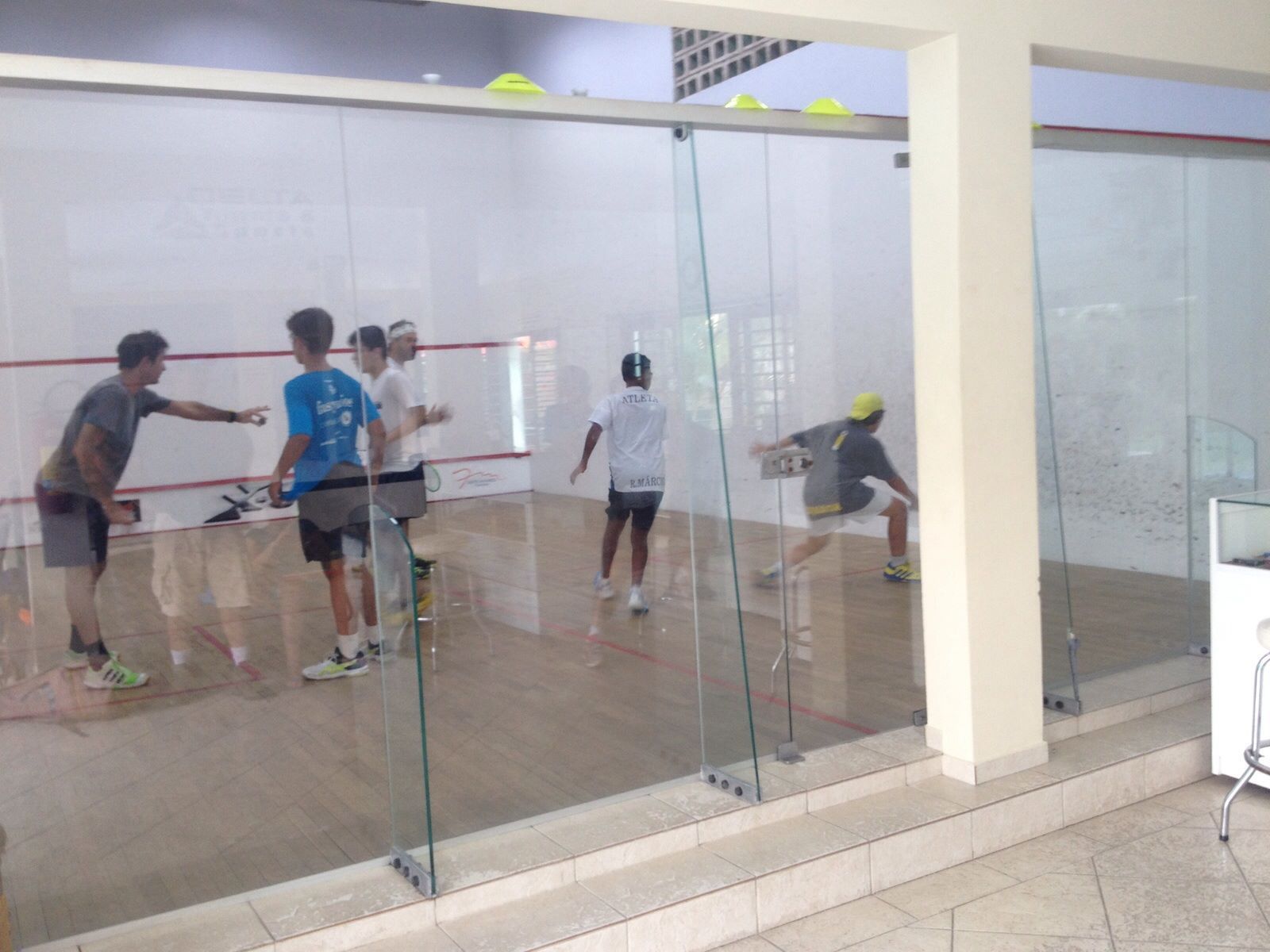 Um grupo de pessoas está jogando squash em uma academia