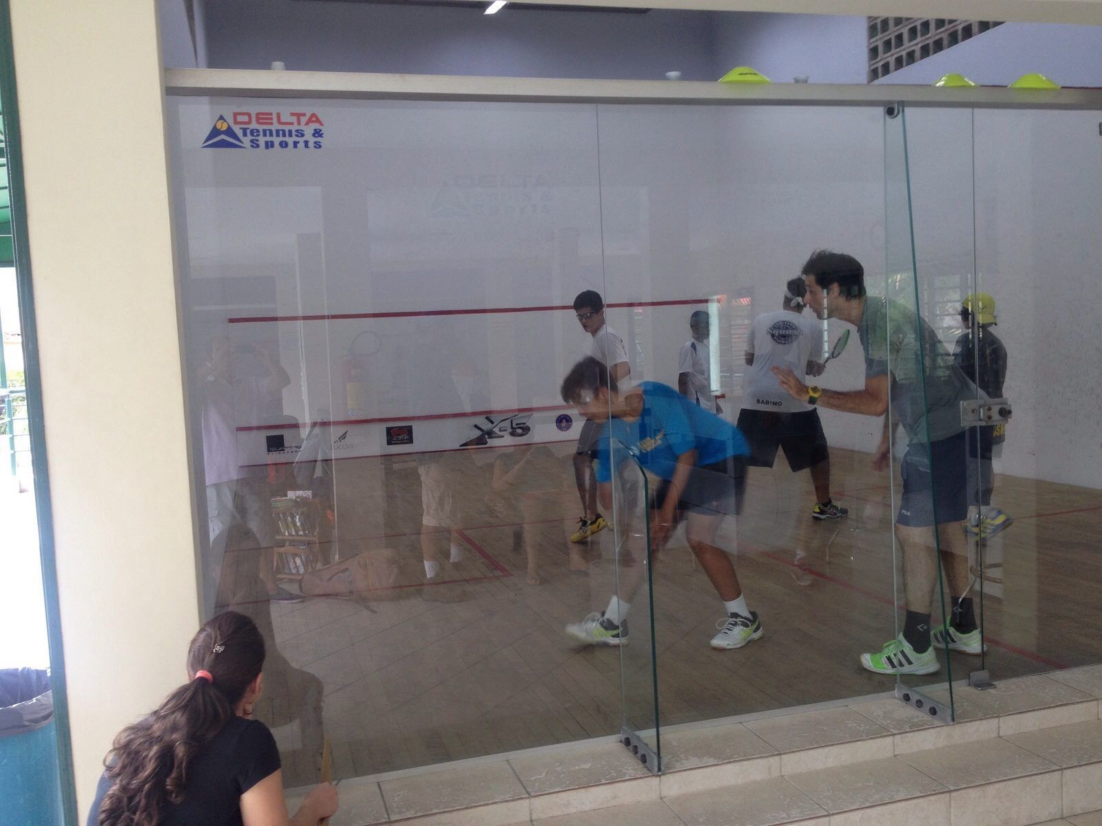 Um grupo de pessoas está jogando squash em uma academia