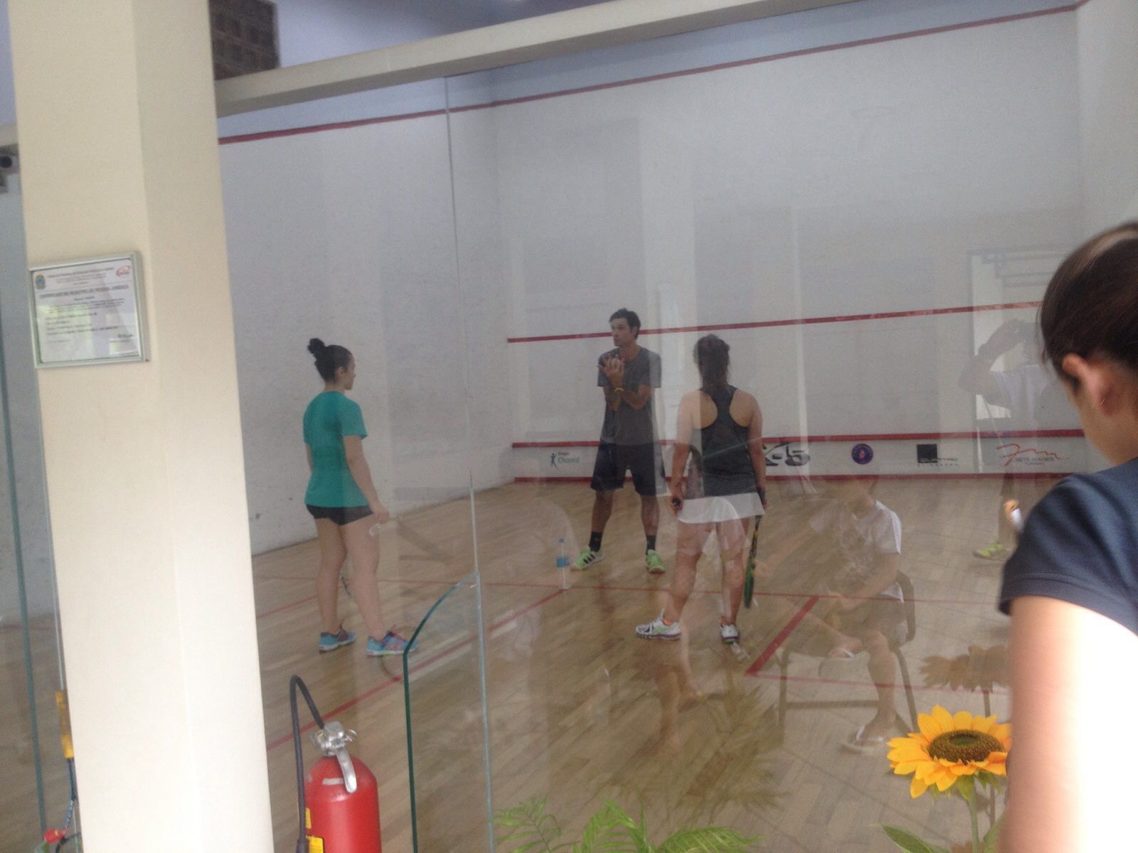 Um grupo de pessoas está jogando squash em uma academia.