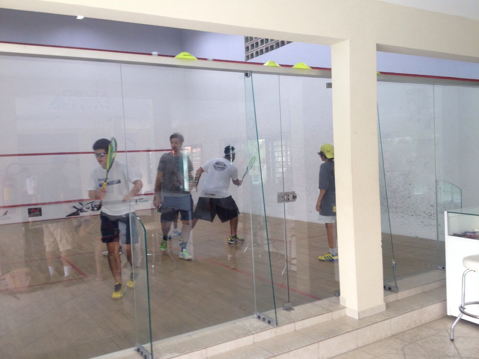 Um grupo de homens está jogando squash em uma academia