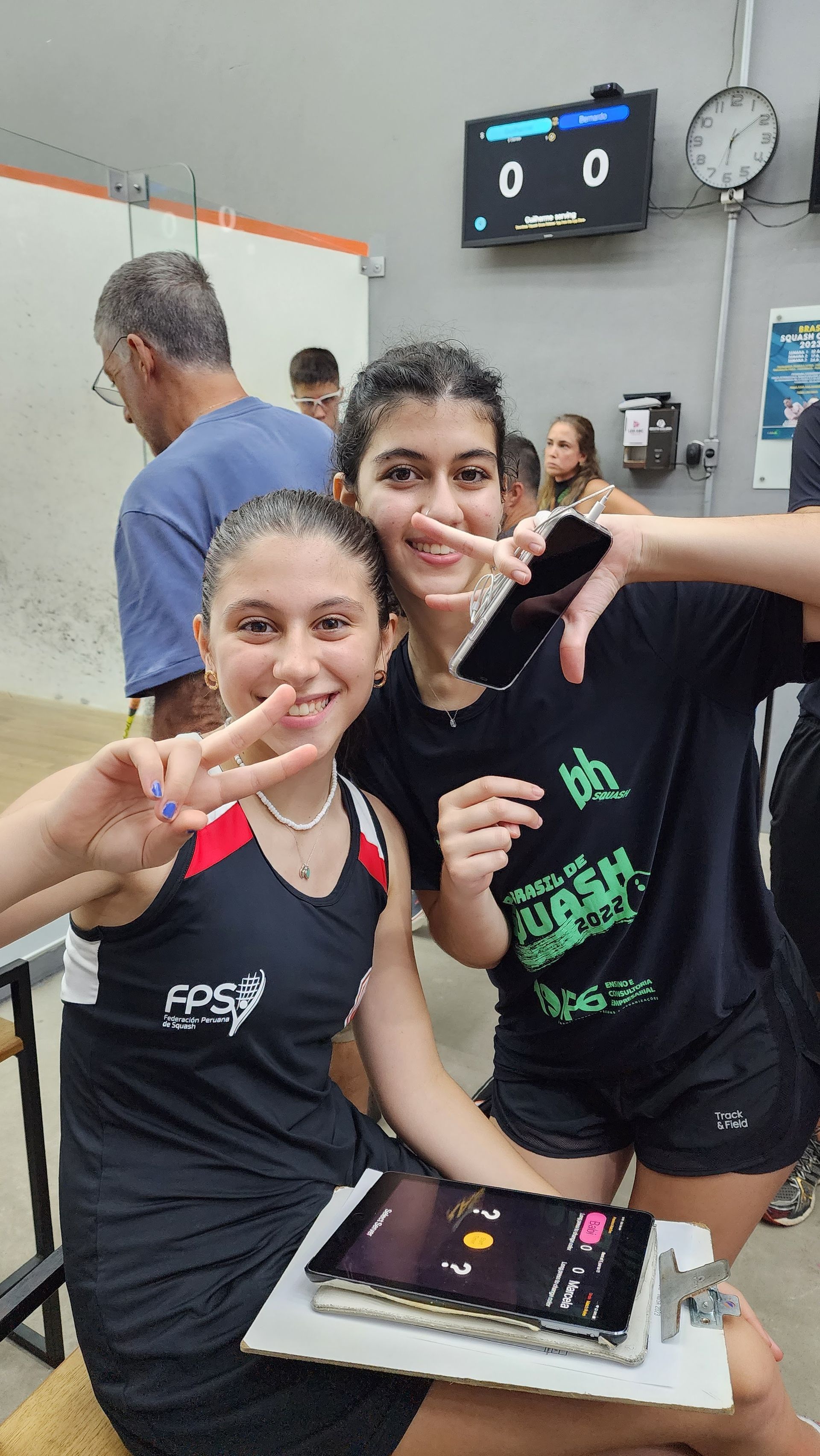 Duas meninas estão sentadas uma ao lado da outra segurando um bolo.
