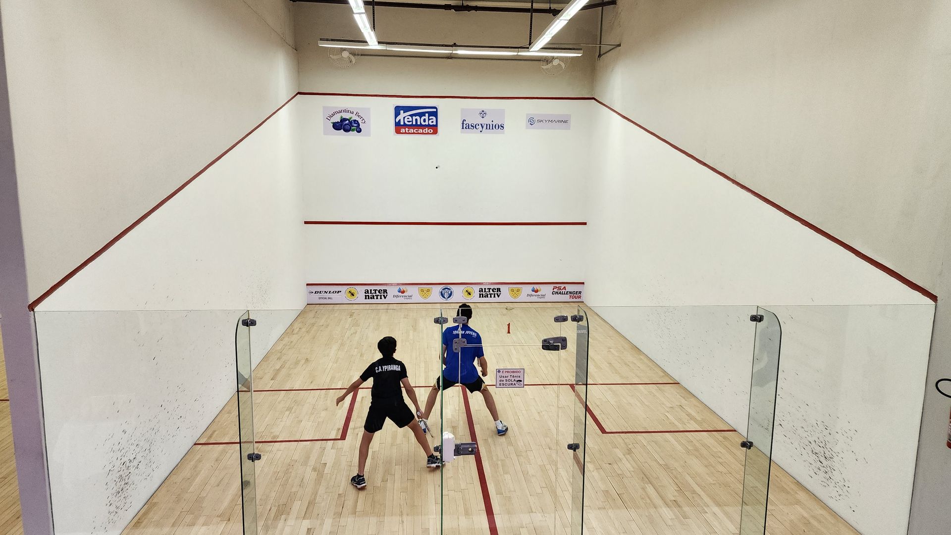 algumas pessoas estão jogando squash em uma quadra