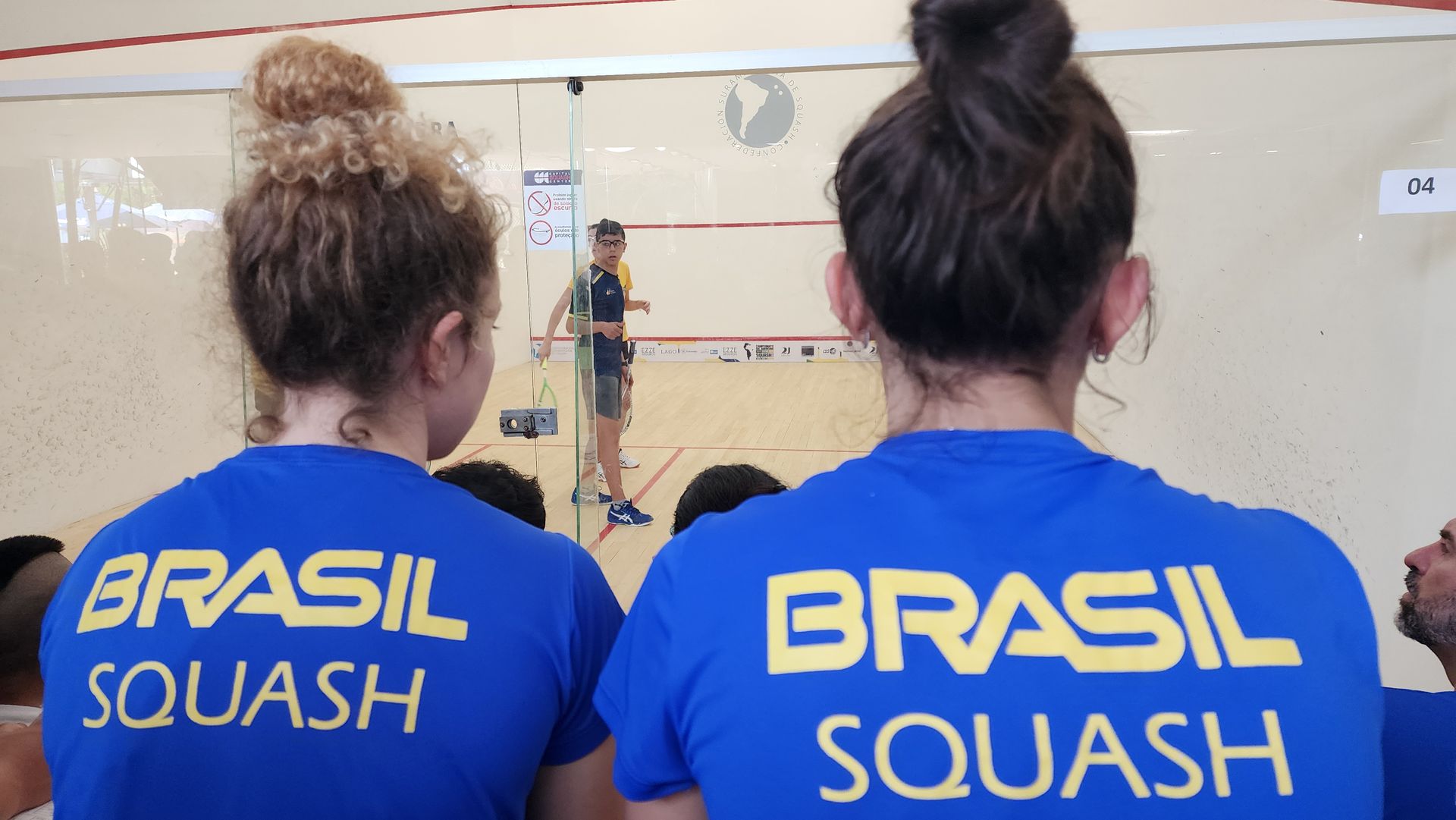 duas mulheres vestindo camisas azuis que dizem brasil squash