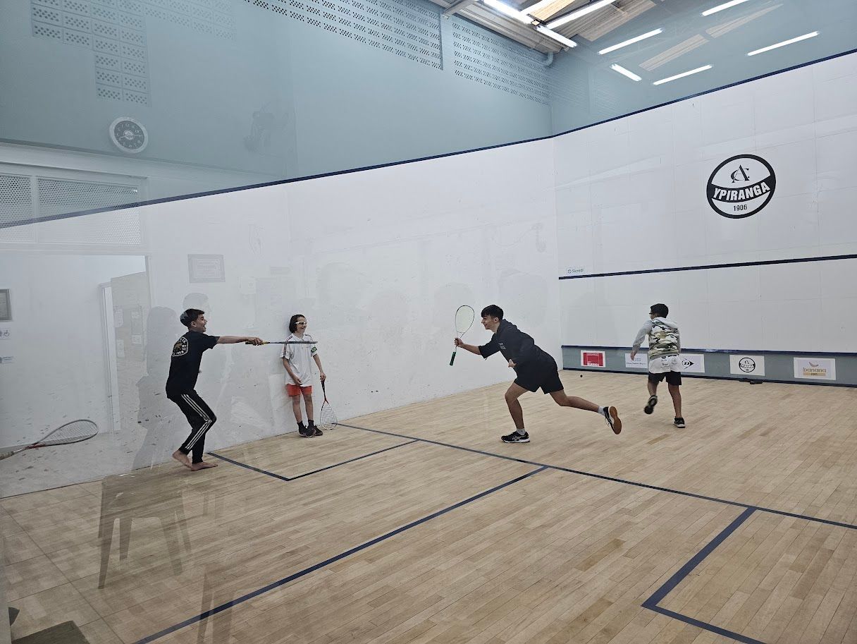 Um grupo de pessoas está jogando squash em uma quadra.