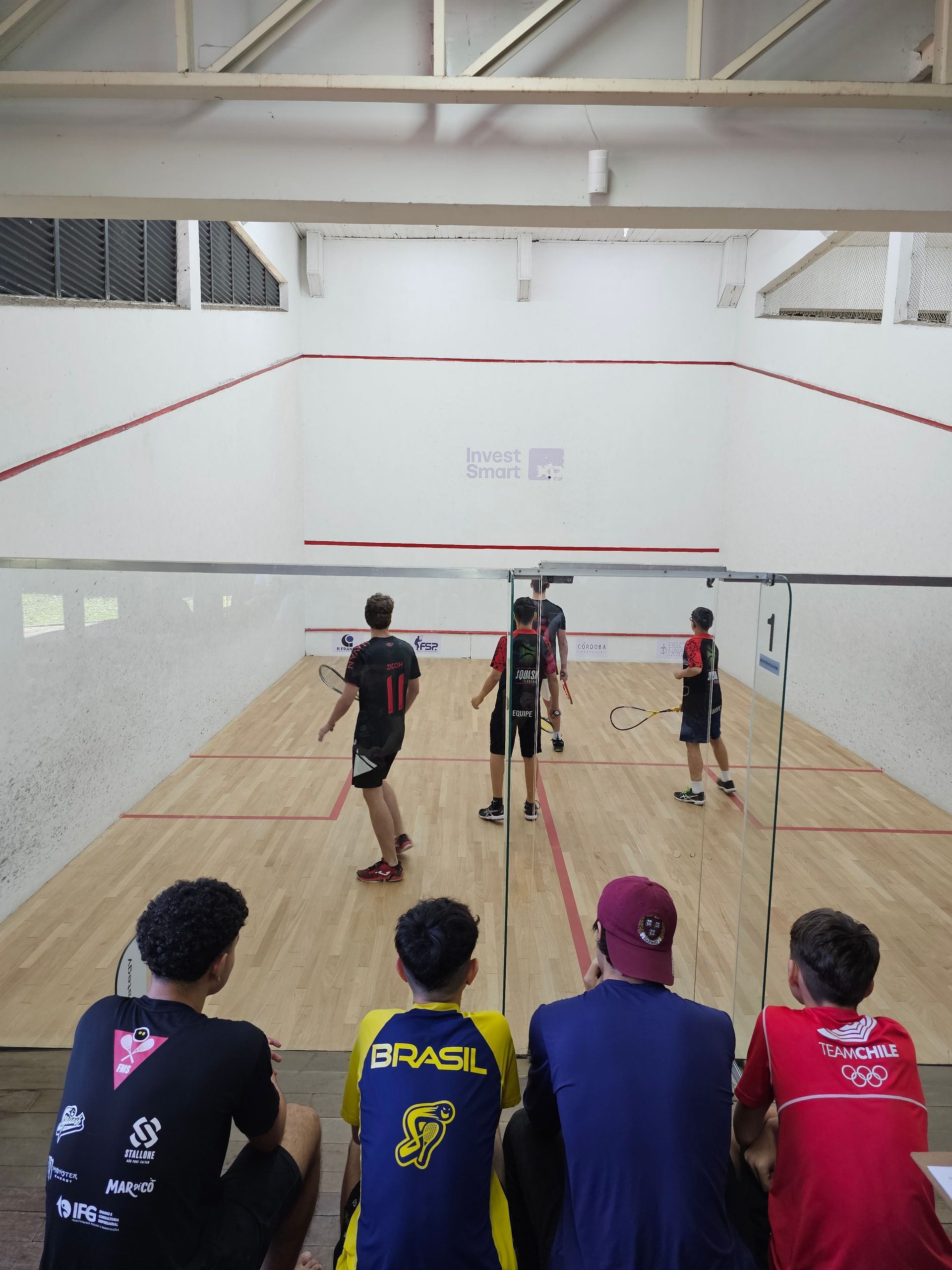 Um grupo de jovens está assistindo a um jogo de squash