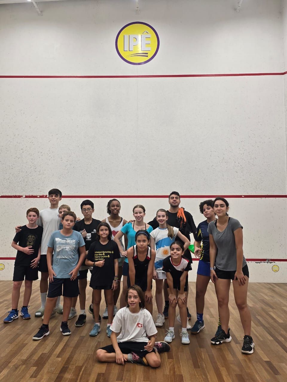 Um grupo de pessoas está posando para uma foto em uma academia.