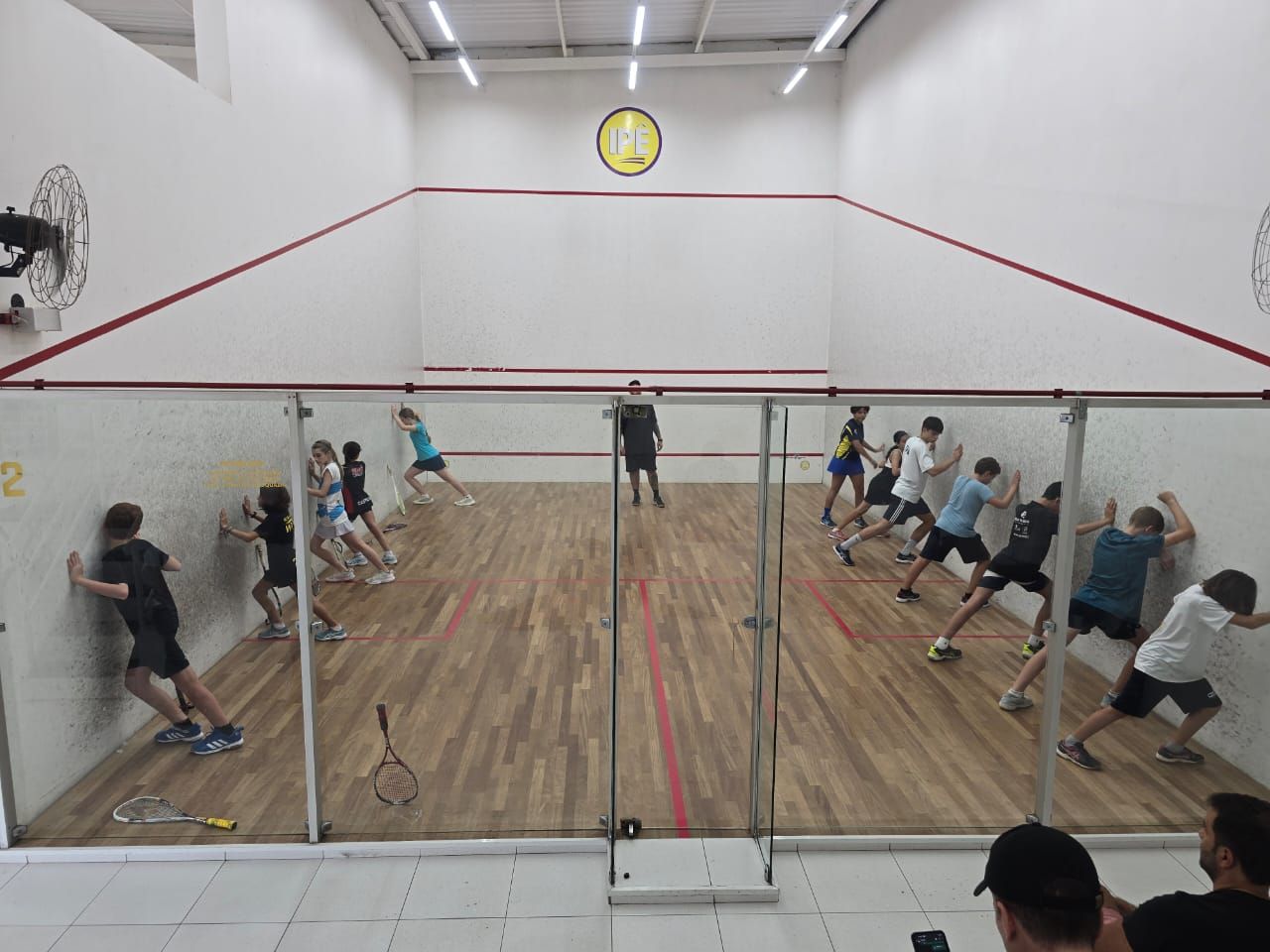 Um grupo de pessoas está jogando squash em uma quadra.