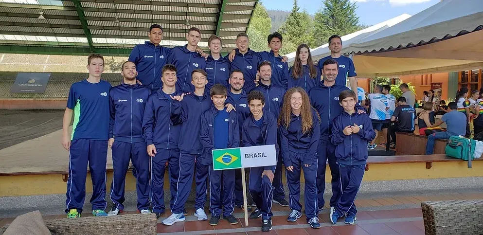 um grupo de pessoas posa para uma foto com uma bandeira.