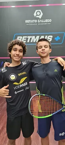 Dois jovens estão posando para uma foto segurando raquetes de tênis.