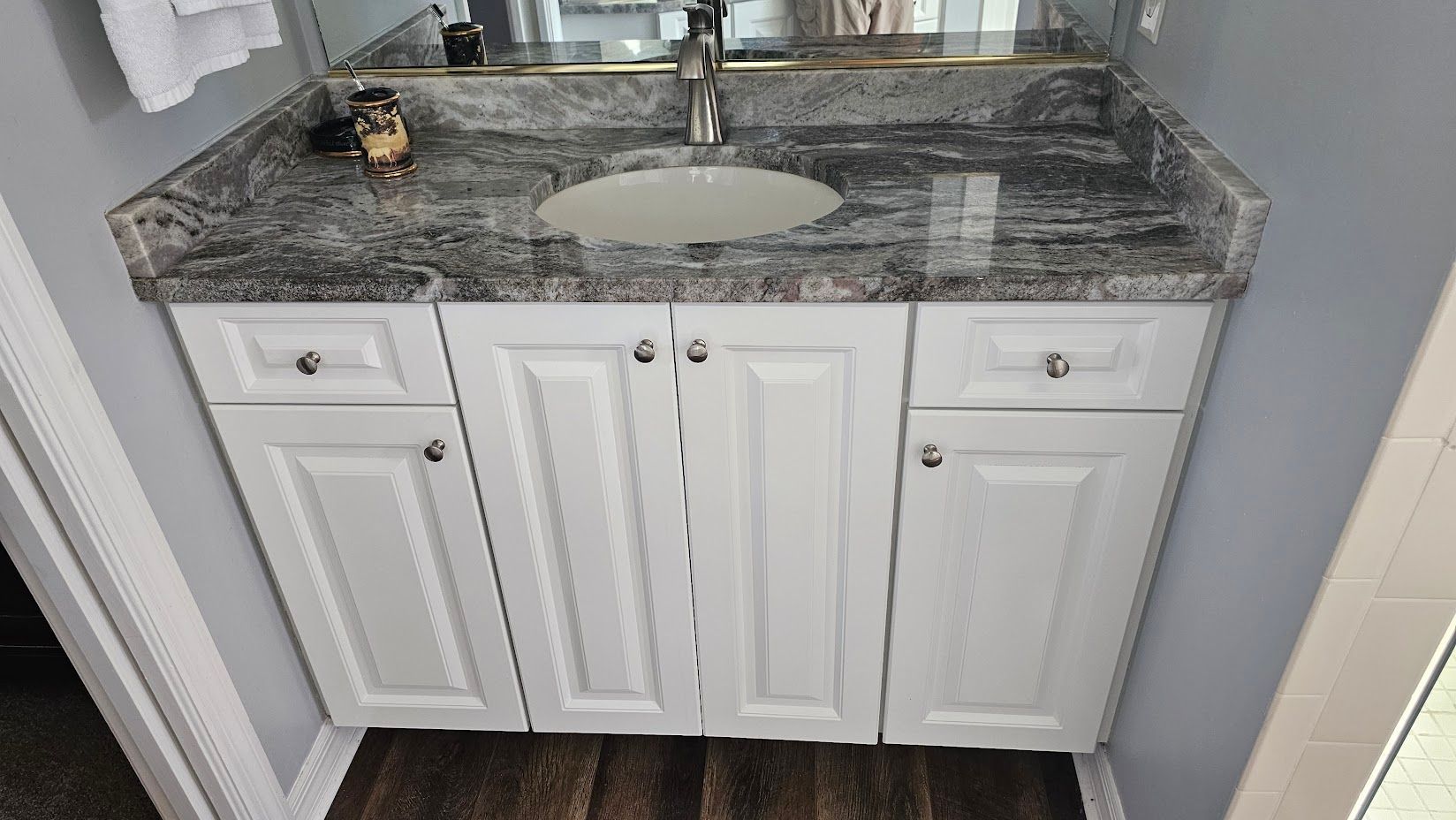 A bathroom vanity with a sink and a mirror.