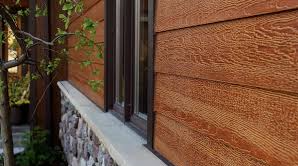 Brown wood siding on a building with stone veneer and window. 