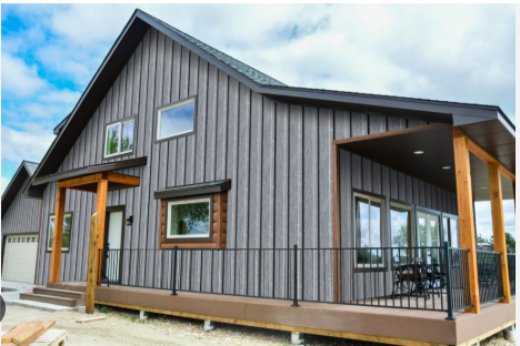 Gray house with wooden porch and vertical steel siding.