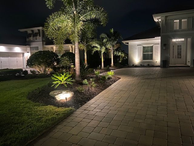 Well-lit driveway entry and gate area with perimeter security lighting