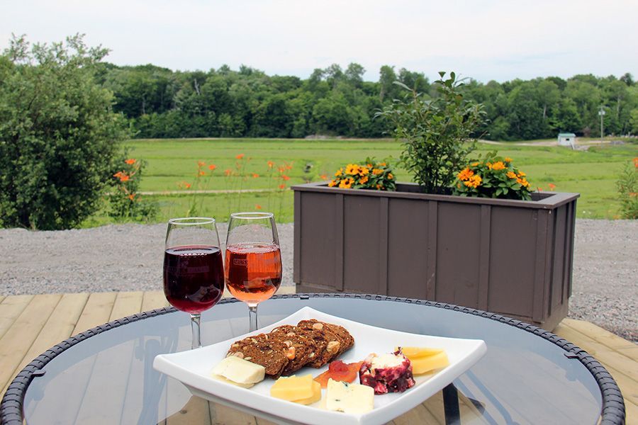 Two glasses of wine and a plate of food are on a table.