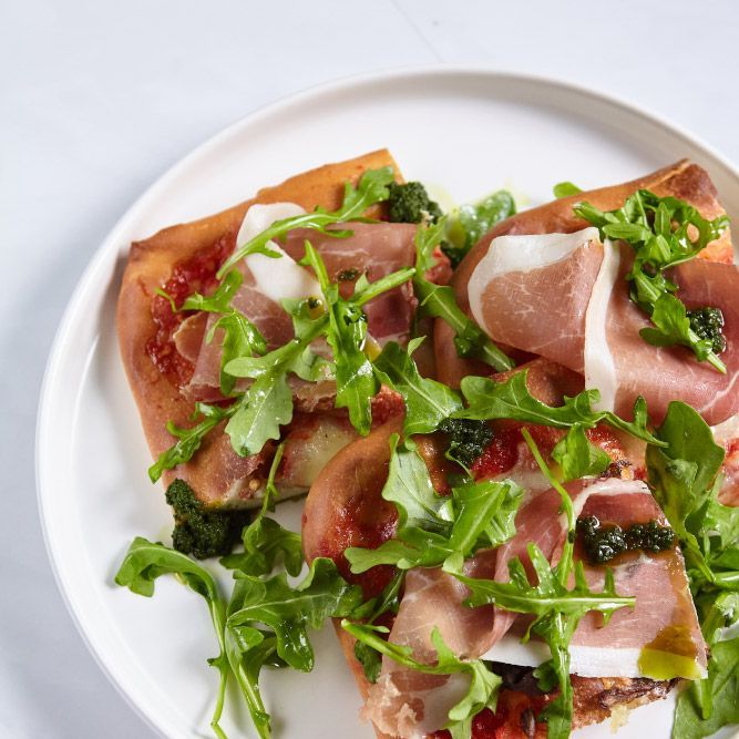 A white plate topped with slices of pizza and vegetables