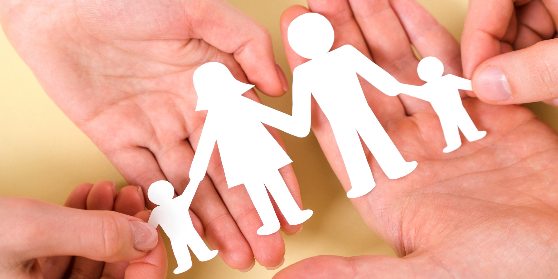 Un gruppo di mani che tengono un ritaglio di carta di una famiglia