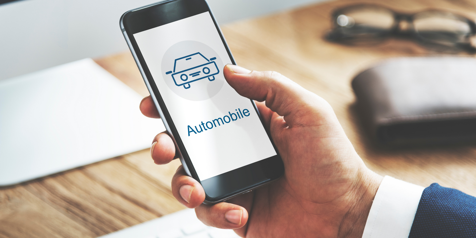Una persona tiene in mano un telefono cellulare con la scritta automobile sullo schermo