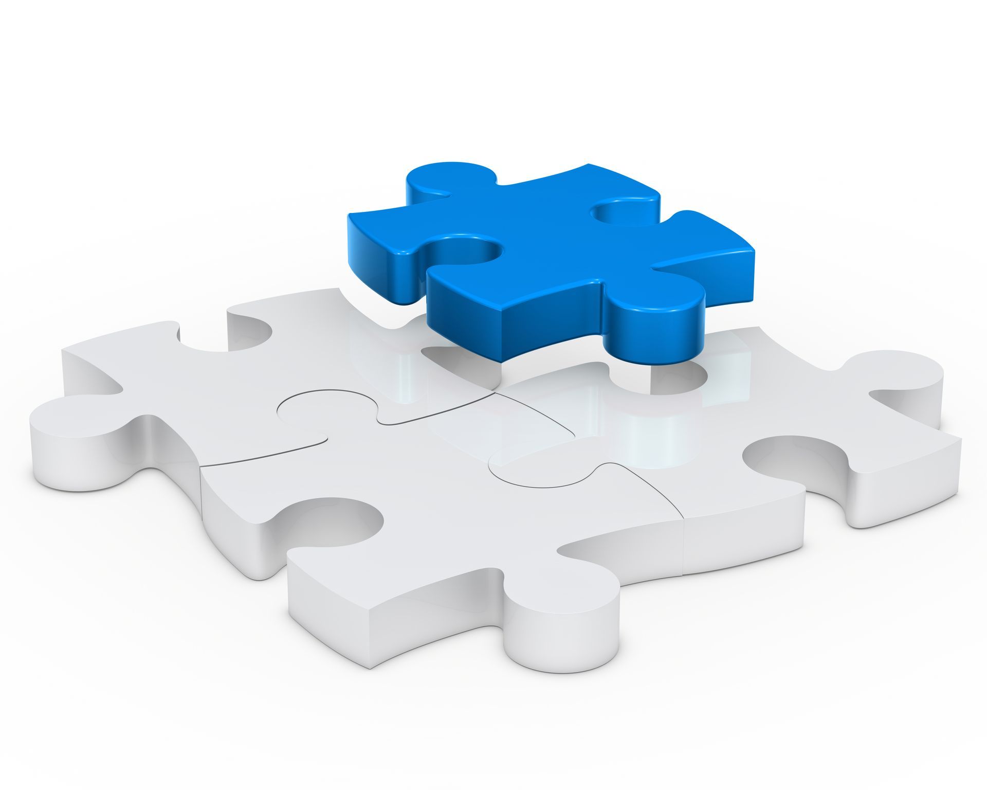 Un pezzo di puzzle blu è appoggiato su un pezzo di puzzle bianco