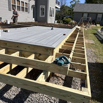 Newly constructed gray composite deck with workers.