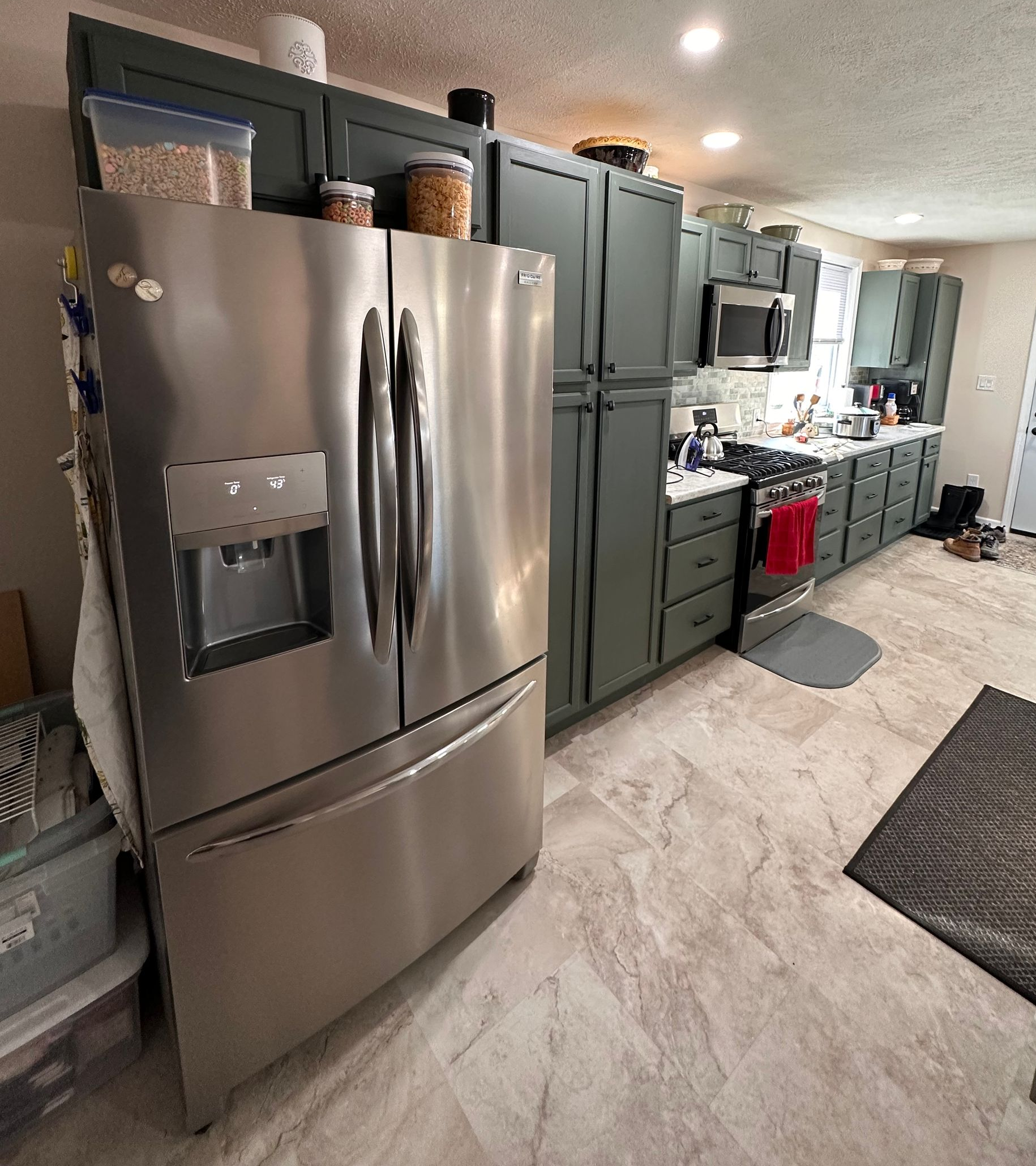 Modern kitchen with walnut cabinets, granite countertops, and a glass tile backsplash.