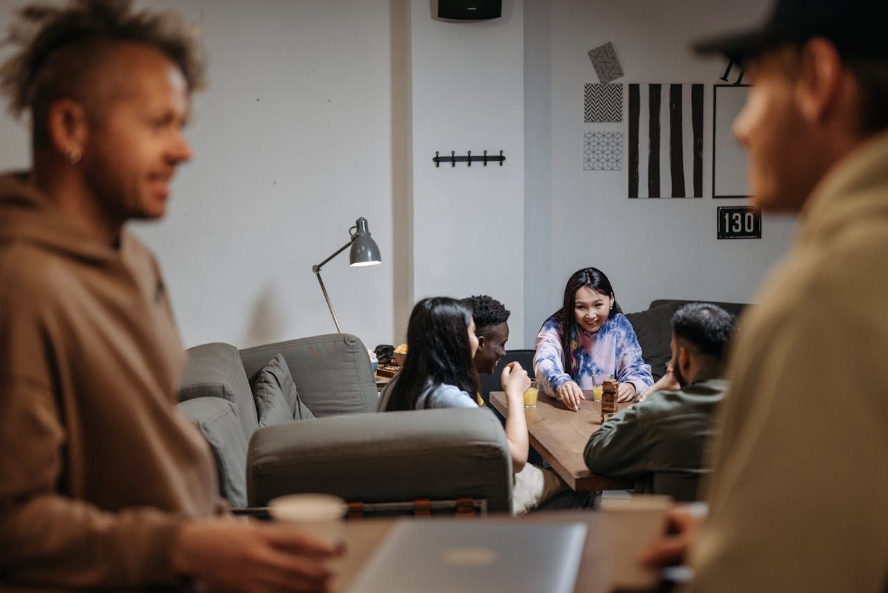 A diverse group of individuals engaged in conversation around a table in a cozy coffee shop setting
