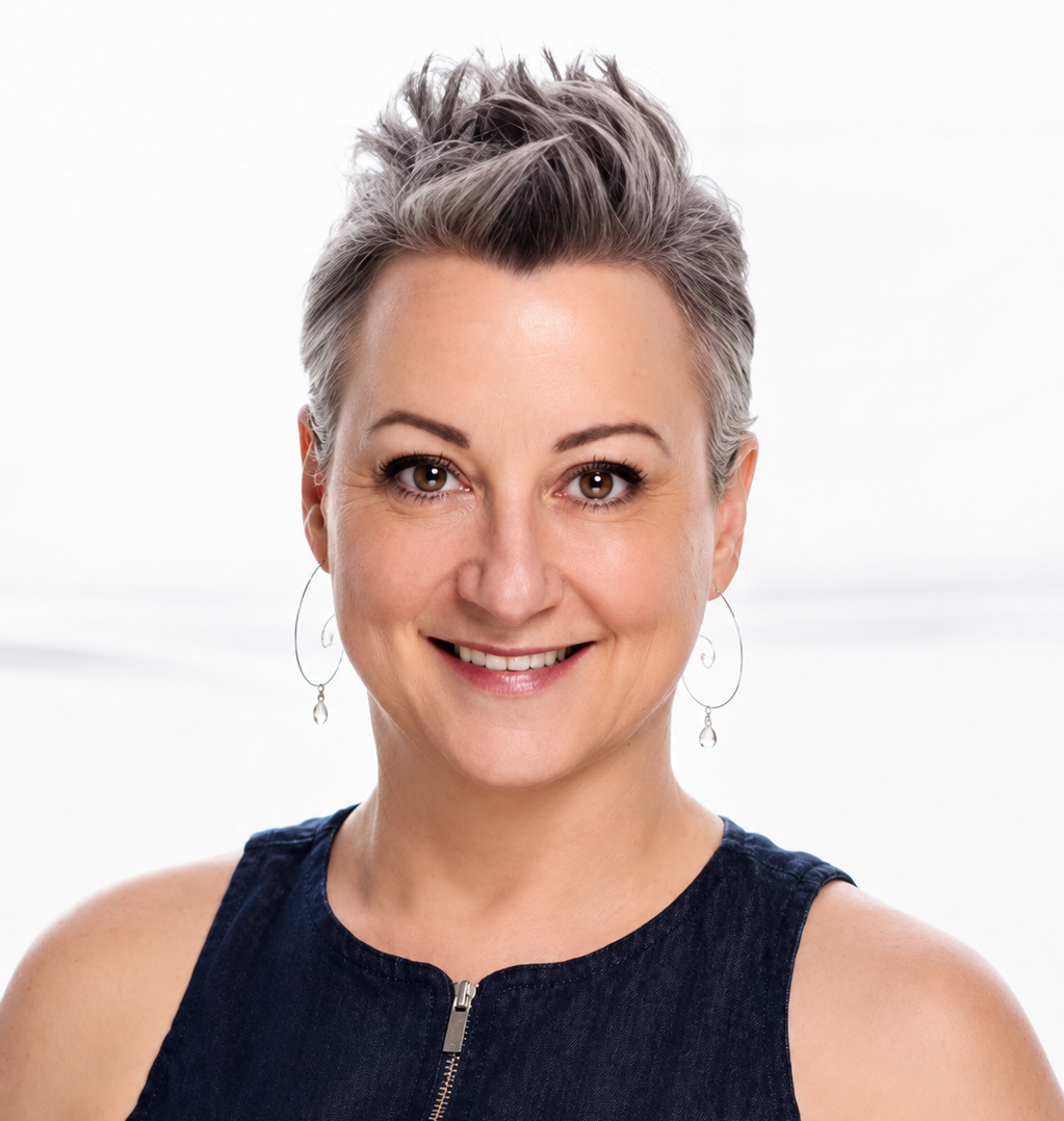 Smiling person with short gray hair and hoop earrings on a white background