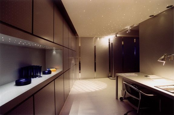 Cucina moderna con eleganti mobili, piano di lavoro e calda illuminazione ambientale.