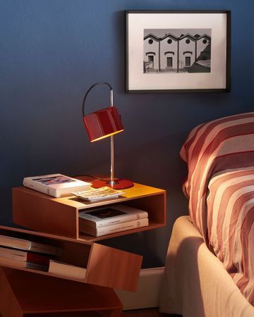 Soggiorno moderno con divano beige, parete nera, lampada da terra e tavolino rotondo.