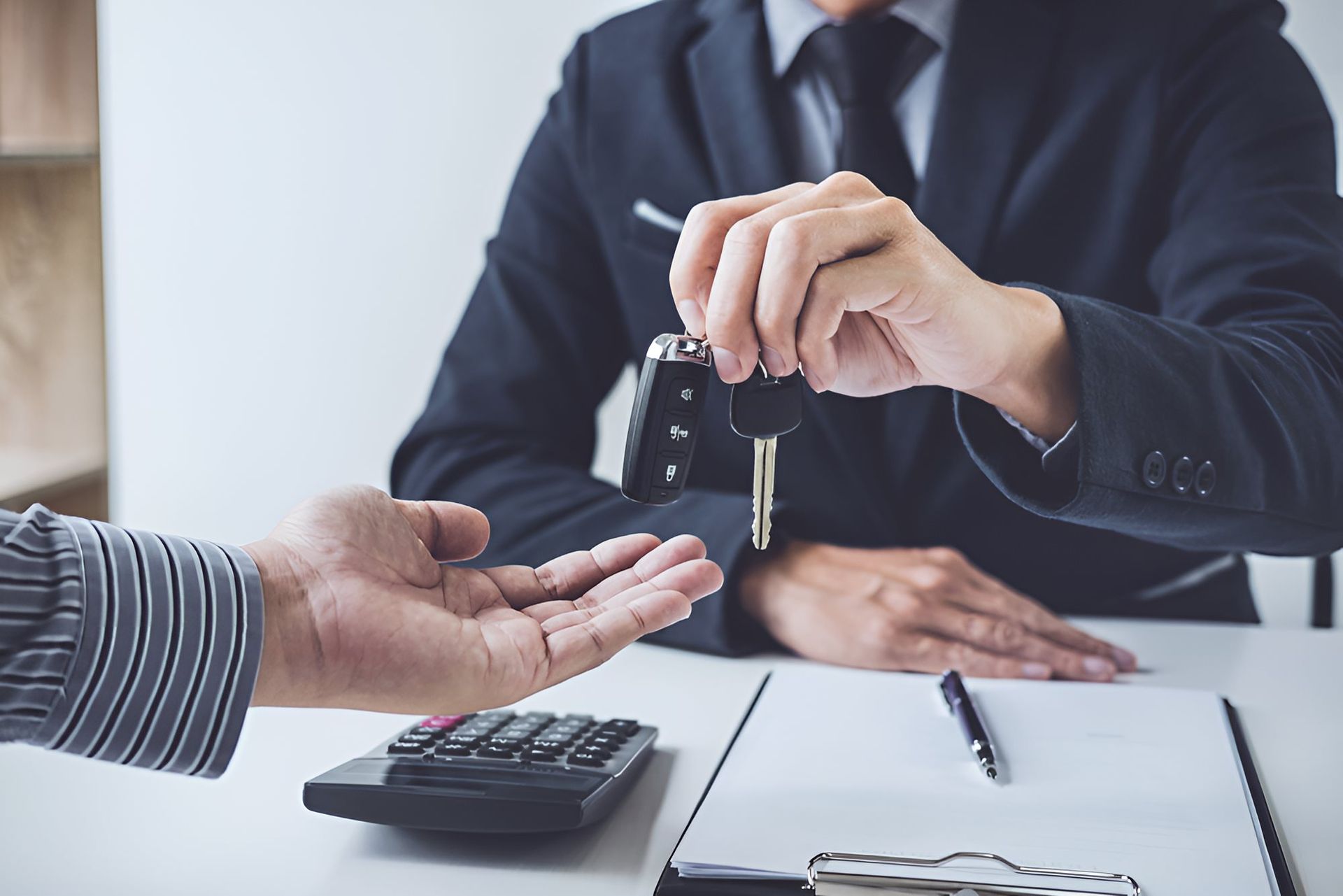 A Man is Giving a Car Key to Another Man — Optimus 1 Insurance Brokers in Townsville, QLD