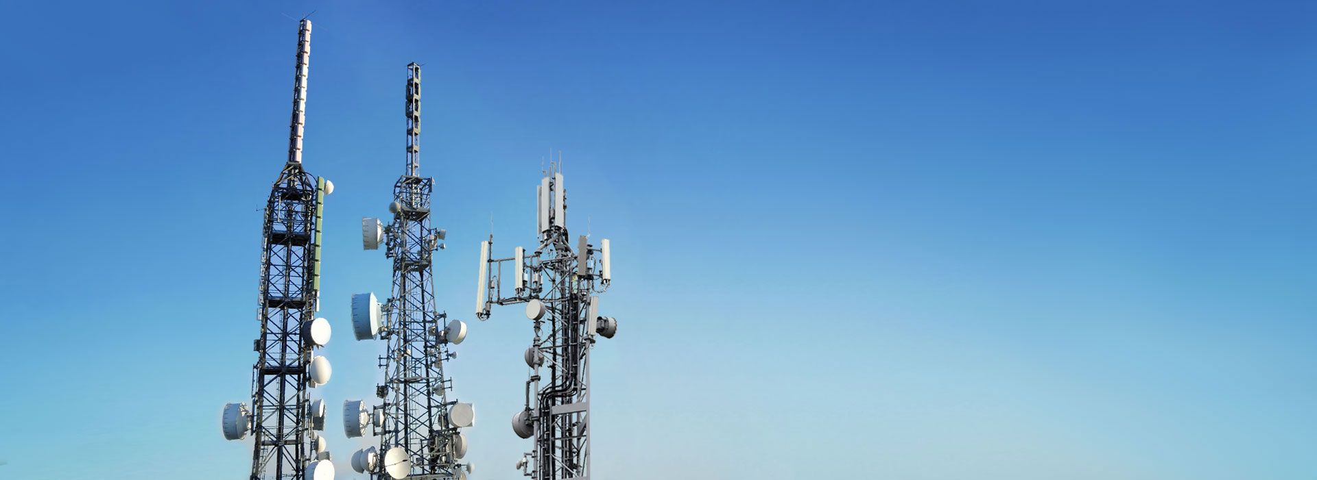 Cell towers against a clear blue sky.