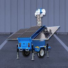 A blue trailer with solar panels on it is parked in a parking lot