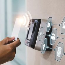 A person is holding a card in front of a security system.