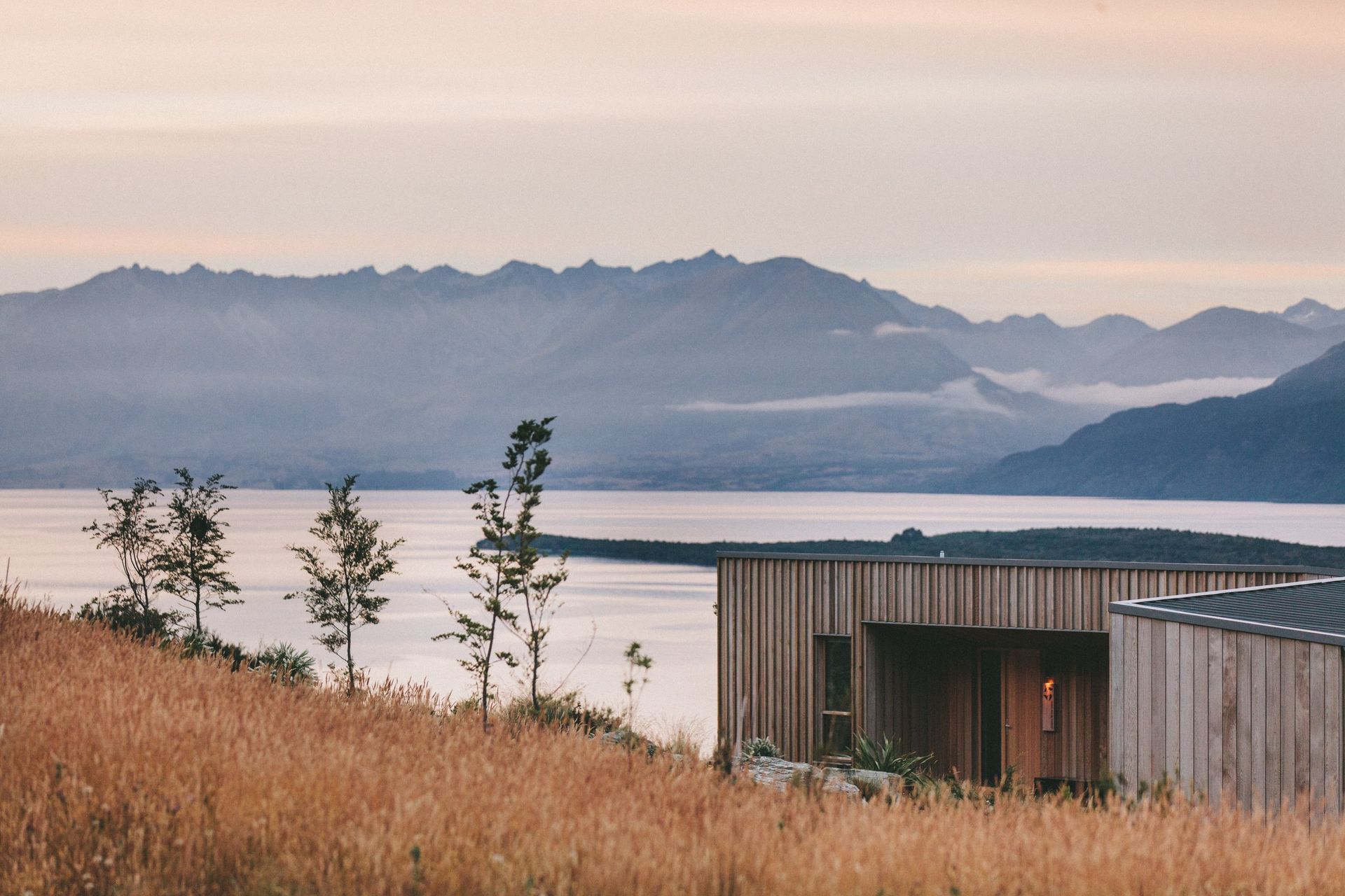 A house with a view of a lake and mountains in the background