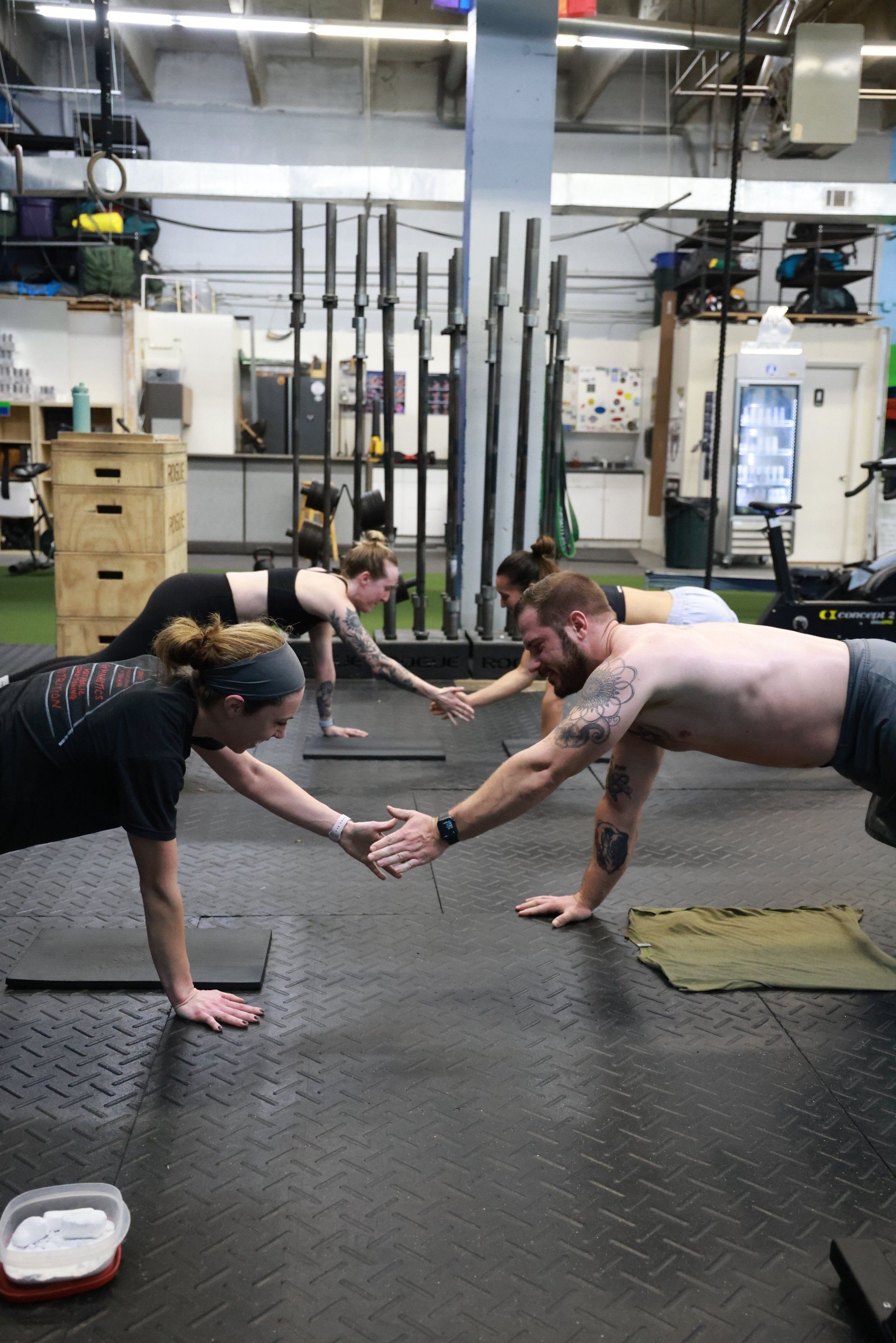 A group of people are doing push ups in a gym.