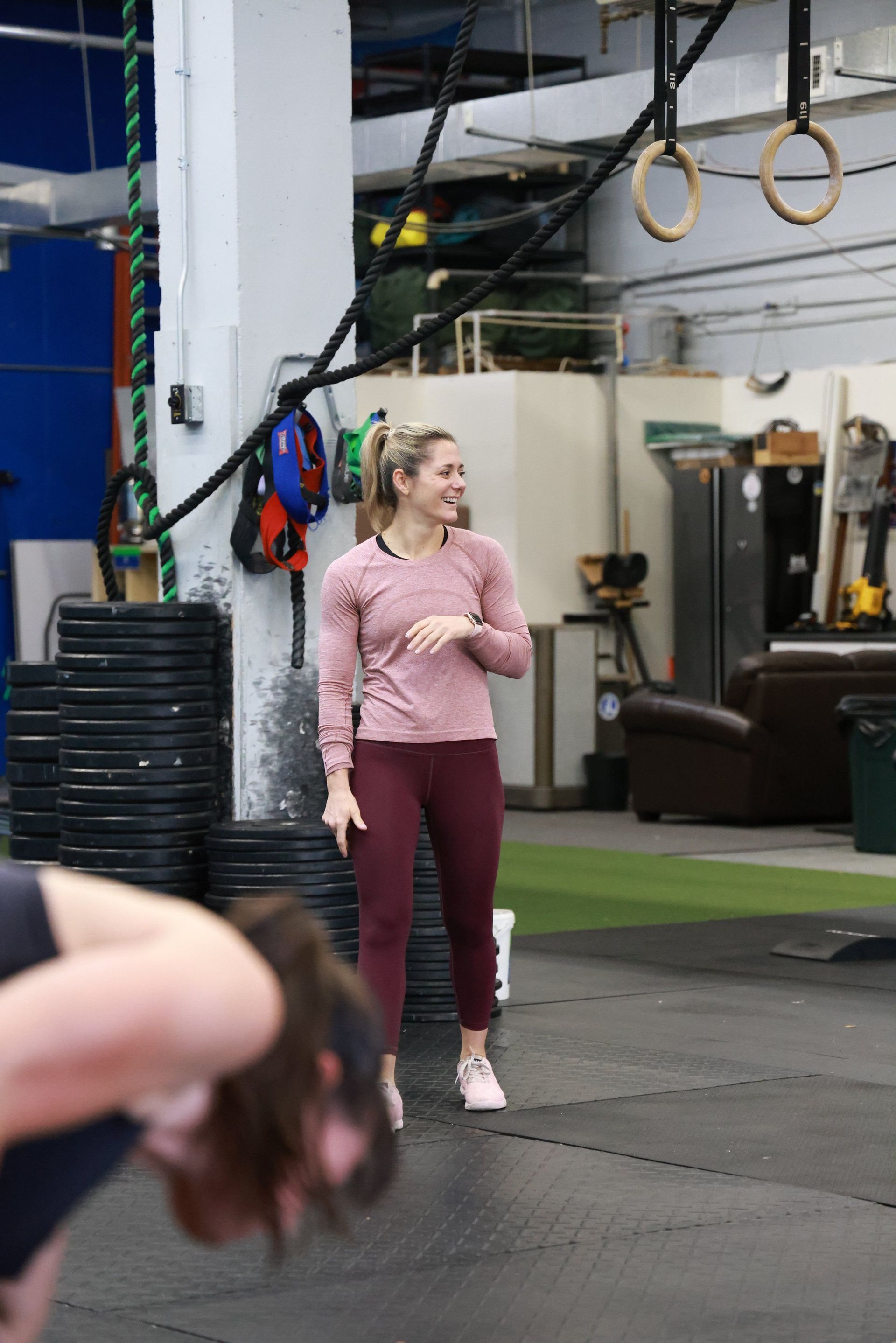 A woman is standing in a gym talking to another woman