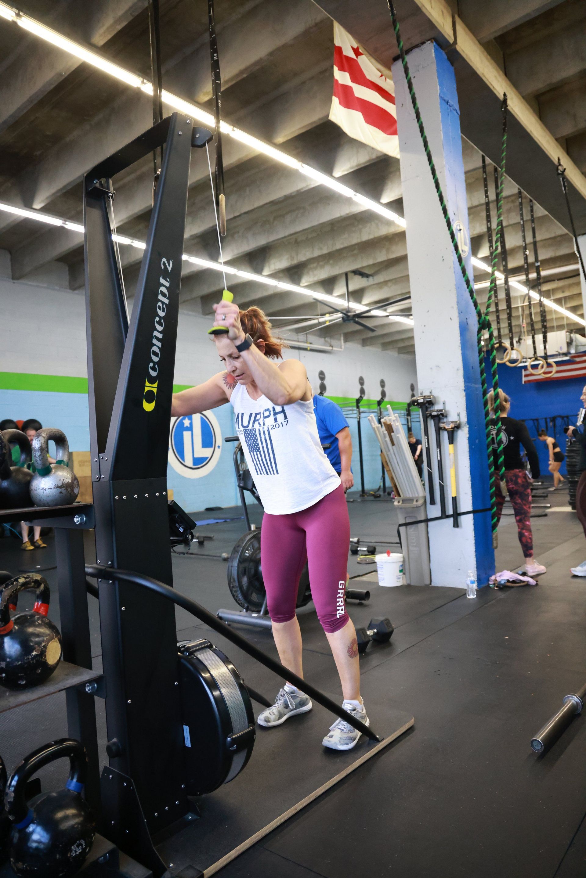 A woman is standing in front of a machine in a gym.