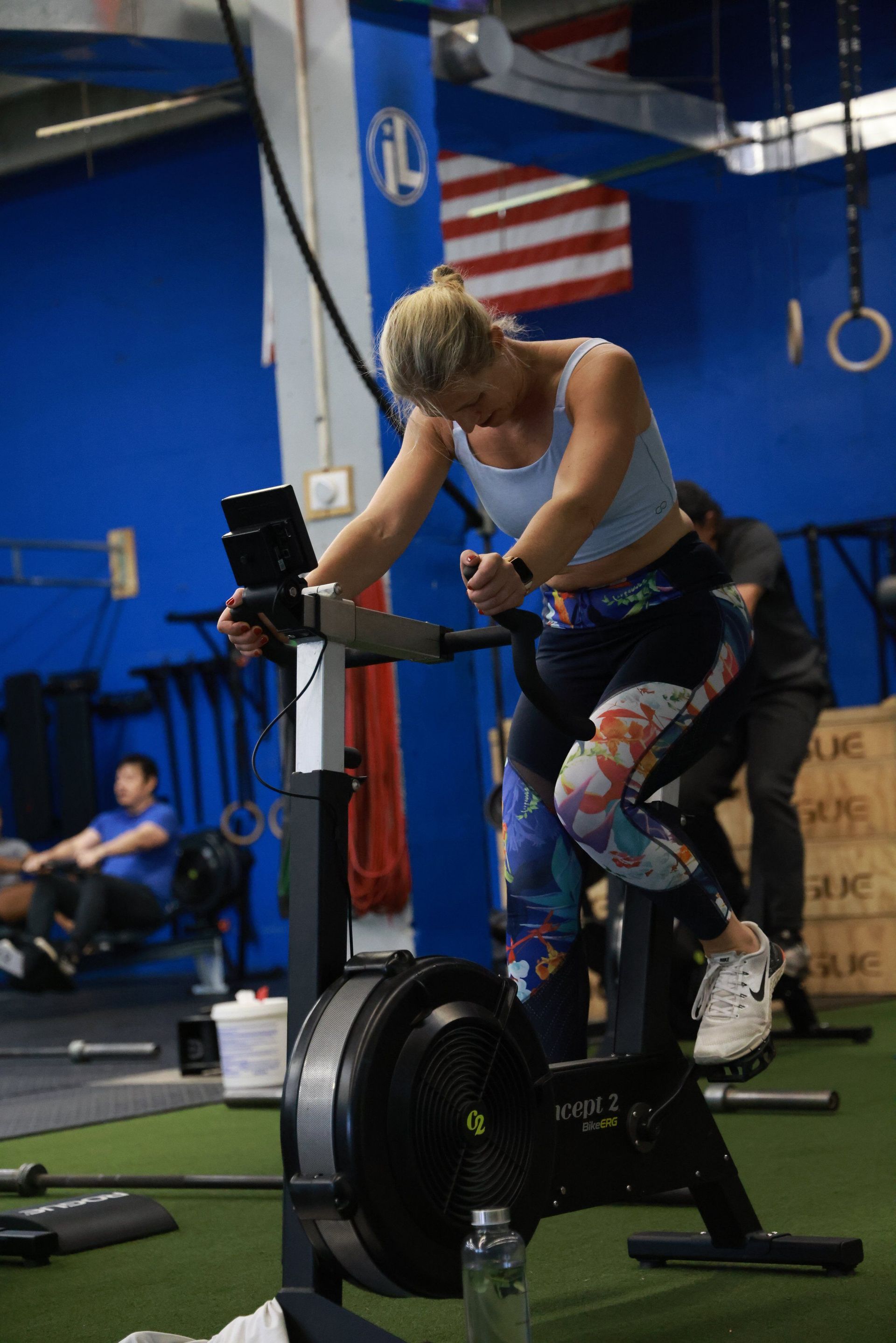 A woman is riding an exercise bike in a gym.