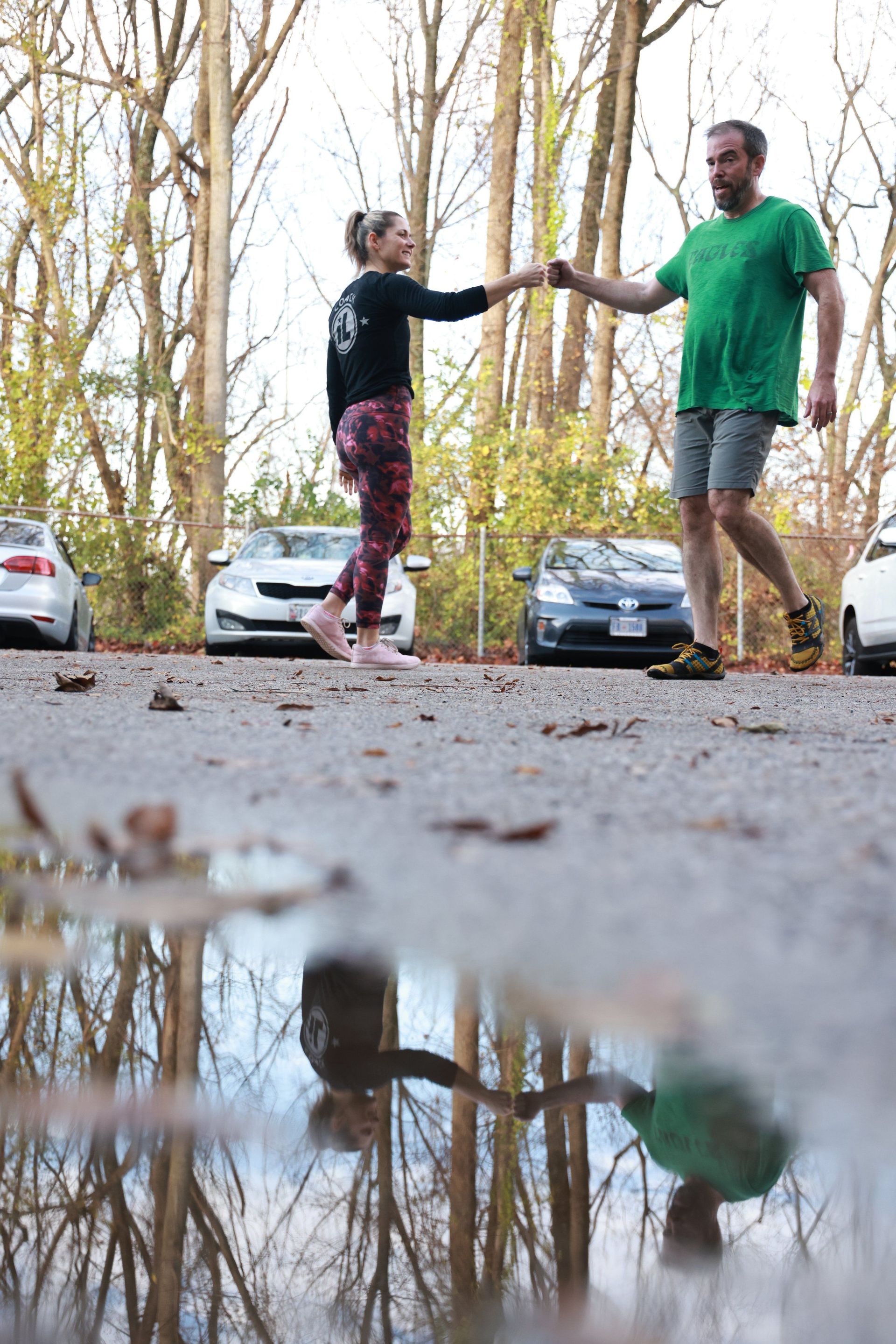 A man and a woman are holding hands while walking down a street.
