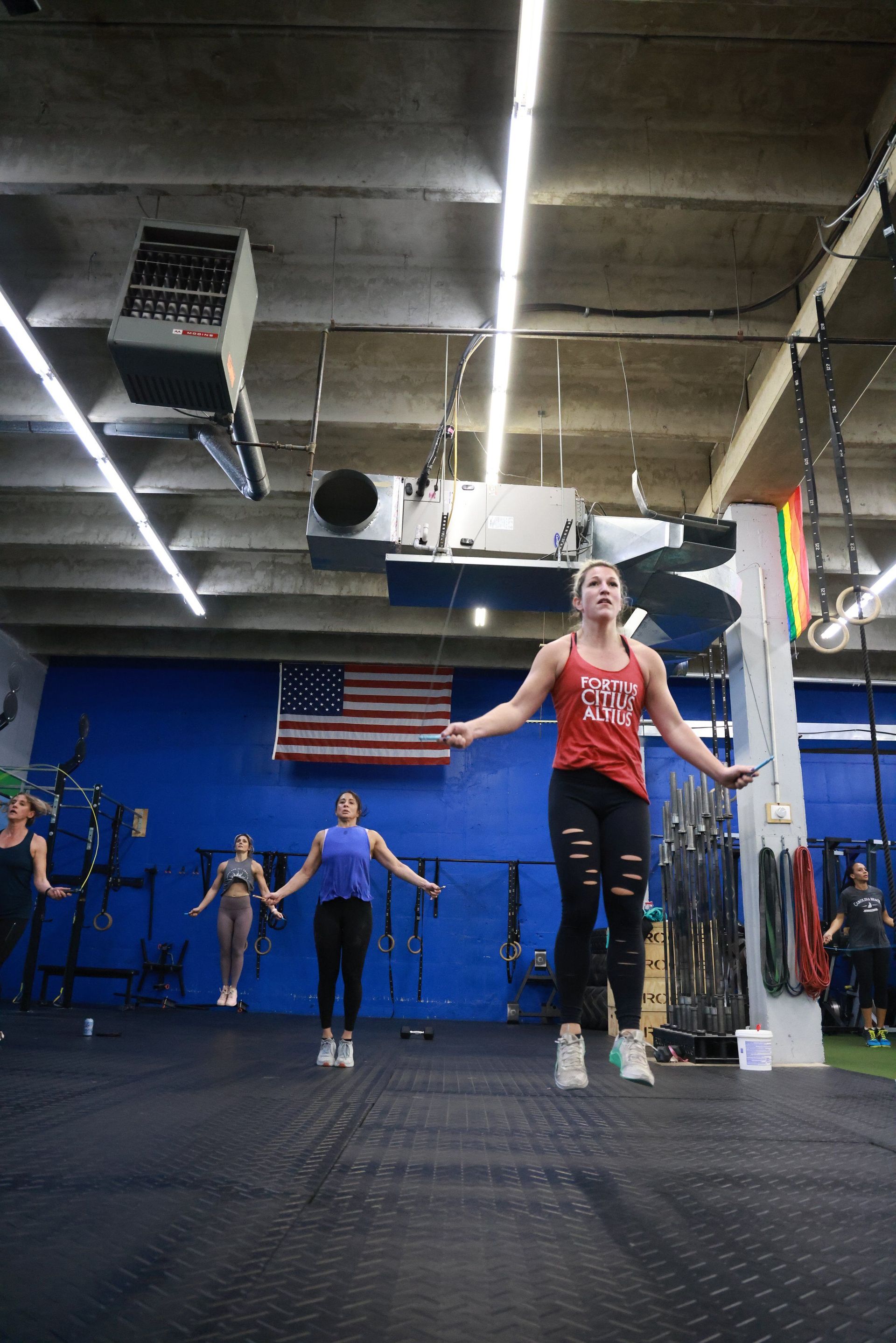 A group of women are jumping rope in a gym.