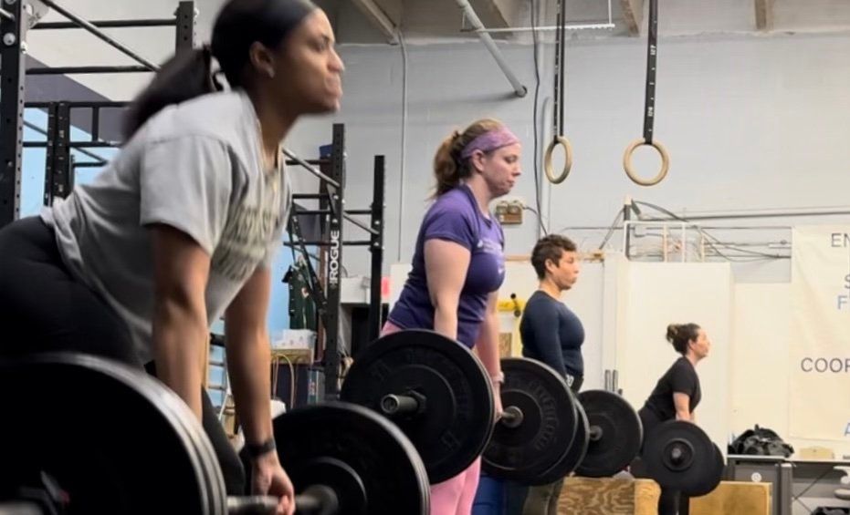 A group of women are lifting weights in a gym.