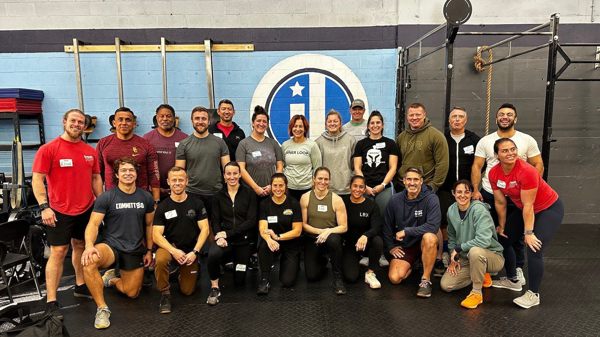 A group of people are posing for a picture in a gym.