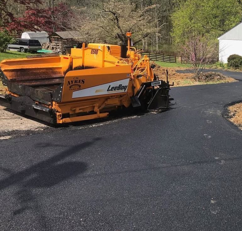 A yellow loading machine is parked on the side of a road