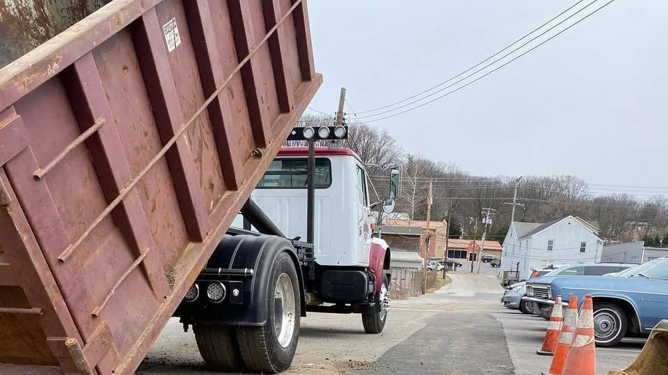 A dump truck is parked on the side of the road.