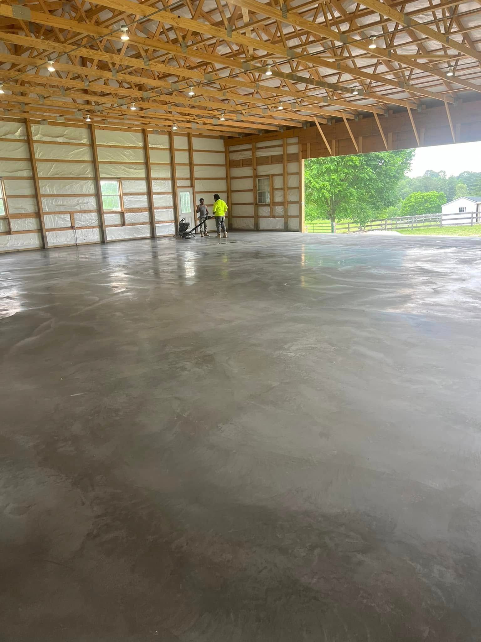 A large warehouse with a concrete floor and a wooden roof.