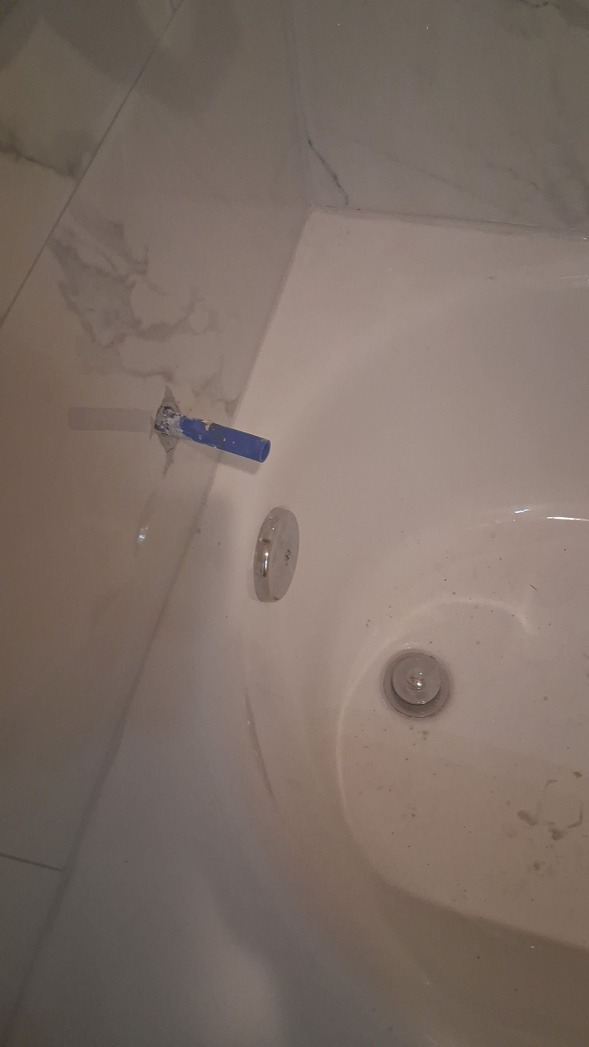 Bathroom sink with a blue toothbrush holder on the wall and a white basin below.